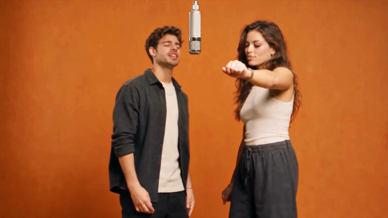A European duo performing in an orange Hotel Lobby AI studio